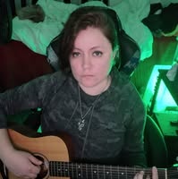 Dani Volare with an acoustic guitar